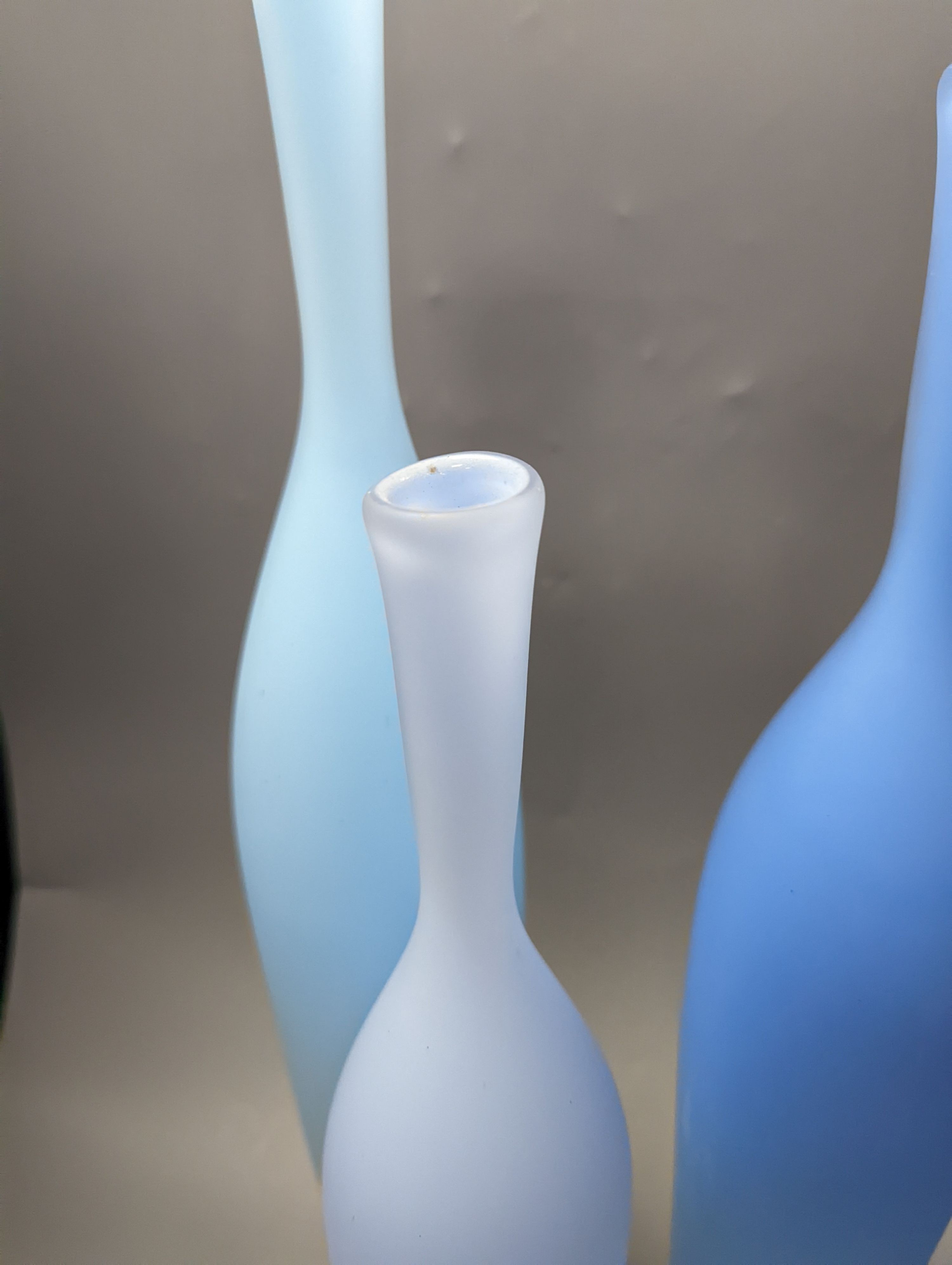 Three contemporary blue glass bottle vases, tallest 55cms high.
